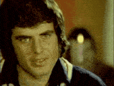 a close up of a man 's face with a blurry background behind him