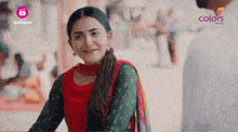 a woman in a red and green dress is smiling in front of a jio cinema logo