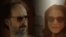 a man with a beard and a woman wearing sunglasses are looking at each other