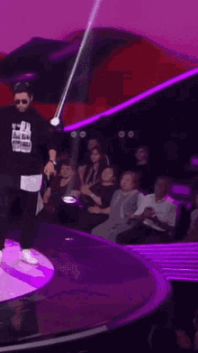 a man is standing on a stage in front of a crowd .