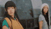 two girls are standing next to a van with a sticker on the window that says ' sally '