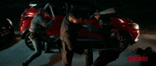 a man holding a sword in front of a red car with the word brothers on the bottom