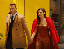 a man and a woman are holding hands while walking