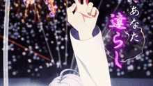 a person is holding up their hand in front of a fireworks display in a foreign language .