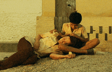a boy and a woman are laying on the ground with the letter h on the wall