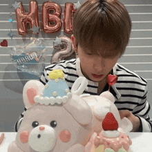 a boy is looking at a cake that has a strawberry on top