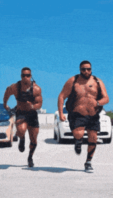 two men are running in a parking lot and one has a sticker on his chest that says ' a ' on it