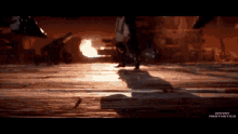 a person walking on a wooden floor in front of a fire with the words spawn aesthetics on the bottom right