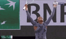a woman is holding a tennis racquet in front of a bnp ad