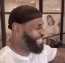 a man with a beard is making a funny face in a room .