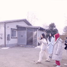 a group of girls are walking in front of a building with a sign on it that says ' a '