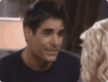 a man and a woman are looking at each other in a room .