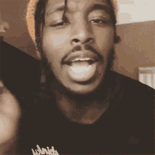 a man with dreadlocks and a beard is wearing a black t-shirt that says ' lithium ' on it