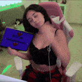 a woman is sitting in a pink chair holding a tablet that says gifs de talightmoon