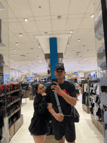 a man and a woman are posing for a picture in a clothing store