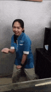 a woman wearing a blue shirt that says ' noola ' on it