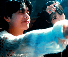 a man and a woman are standing next to each other and the woman is holding a feather in her hand