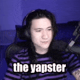 a man wearing headphones is sitting in front of a microphone and saying the yapster .