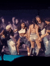 a group of people are dancing on a stage and one of them is wearing a shirt that says ' a '