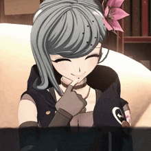 a girl with a flower in her hair is smiling with her hand on her chin