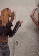 a couple of women are standing next to each other in a room .