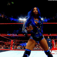 a woman with blue hair is standing in a wrestling ring with the words world train on the bottom