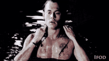 a man with a tattoo on his chest is swimming in the water