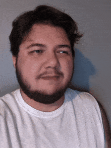 a man with a beard is wearing a white t-shirt