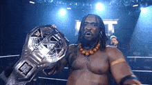 a man with dreadlocks is holding a wrestling championship belt .
