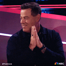 a man is praying with his hands folded in front of him