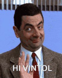 a man in a suit and tie is waving his hand with the words hi vintol below him