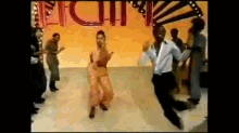 a group of people are dancing on a stage in front of a sign that says ' rhythm ' .