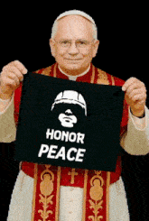 a priest is holding up a black sign that says honor peace