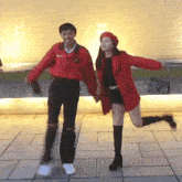 a man in a red jacket holds hands with a woman