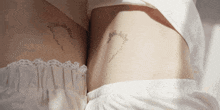 a woman 's stomach has a tattoo of a circle and flowers