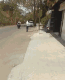 a blurry picture of two people riding motorcycles down a road