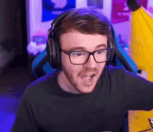 a man wearing glasses and headphones is making a funny face while playing a video game .