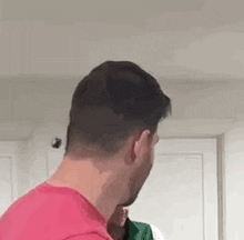 the back of a man 's head is shown in a kitchen .
