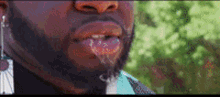 a close up of a man 's mouth with liquid coming out of it