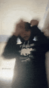 a blurry photo of a person wearing a black shirt that says triller
