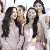 a group of women are posing for a picture and one of them is wearing a crown