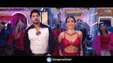 a man and a woman are dancing in front of a sign that says swayamvar