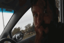 a man with a beard is sitting in a car