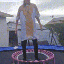 a woman in a dress is jumping on a trampoline