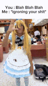 a person dressed as alice from alice in wonderland is giving a peace sign
