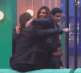 a group of people hugging each other with a green background