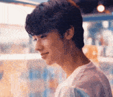 a close up of a young man 's face with a white shirt on