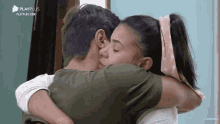 a man and a woman are hugging and kissing with playplus written on the bottom of the screen