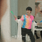 a man in a colorful sequined shirt is holding a green object