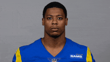 a man wearing a blue and yellow rams jersey
